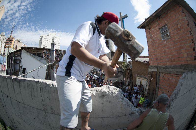 Em 4 de agosto acontece a derrubada oficial do "Muro da Vergonha", como foi batizada a estrutura de concreto armado que Kassab construiu dividindo a favela. Com marretas e britadeiras, os próprios moradores executaram o serviço prometido por Haddad para 15 de julho. Foto/Associação Moinho Vivo